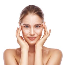 Anti-aging facial massage. Beautiful young woman with white arrows over her face keeping hands on head and looking at camera. Isolated on white background. Skin Care. Massage lines. Cosmetology concept
